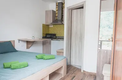 a bedroom with a bed with green pillows on it at Apartmaji Hrast - Podbela in Podbela