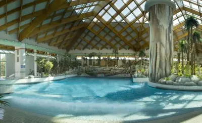 a large swimming pool in a building with a ceiling at Apartma Julija Hiška 59 in Čatež ob Savi