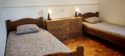 a bedroom with two beds and a dresser with two candles at Apartma Julija Hiška 59 in Čatež ob Savi