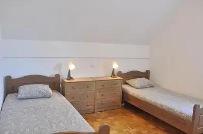 a bedroom with two beds and a dresser with two lamps at Apartma Julija Hiška 59 in Čatež ob Savi
