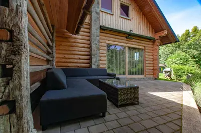 a patio with a couch and a table on a building at Log House Natura in Radovljica