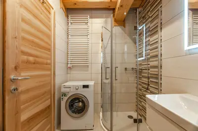 a bathroom with a washing machine and a sink at Log House Natura in Radovljica
