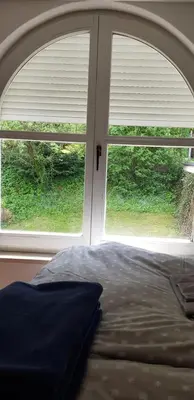a bed sitting in front of a window at Park in Ljubljana