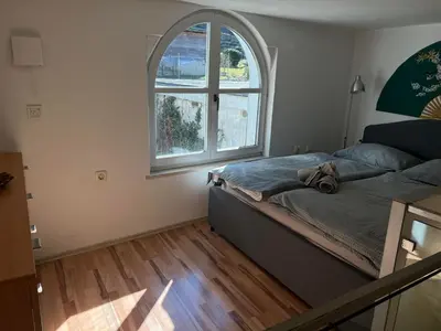 a bedroom with a bed and a large window at Park in Ljubljana