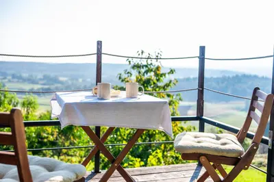 a table and chairs on a balcony with a view at Zidanica Lackner in Črnomelj