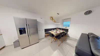 a kitchen and dining room with a table and a refrigerator at Villa Four Stars ART-PE in Trebnje