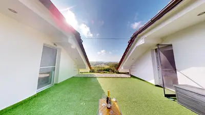 a view from the balcony of a house with green flooring at Villa Four Stars ART-PE in Trebnje