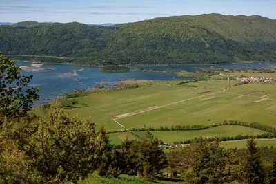 an aerial view of a field and a lake at Dom na Slivnici in Cerknica