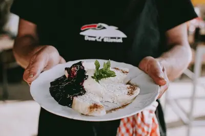 a person is holding a plate of food at Dom na Slivnici in Cerknica