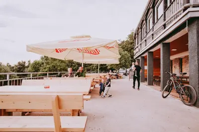 a picnic table with an umbrella on a sidewalk at Dom na Slivnici in Cerknica