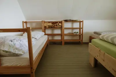 a bedroom with two bunk beds and a book shelf at Dom na Slivnici in Cerknica
