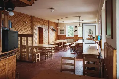 a dining room with wooden tables and chairs at Dom na Slivnici in Cerknica