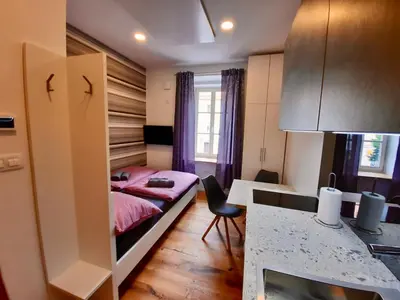 a small room with a bed and a desk at Apartment Silver in Ljubljana