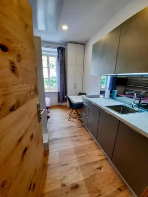 a kitchen with a wooden door and a table at Apartment Silver in Ljubljana
