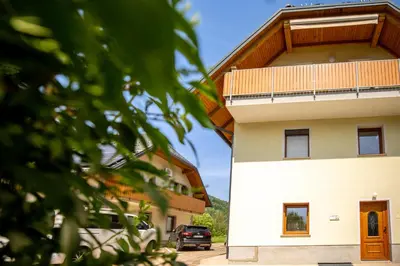 a building with a car parked next to it at Apartma Lovor in Bohinj