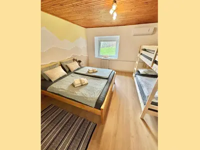 a bedroom with a bed and two bunk beds at Hurja Apartments in Kobarid