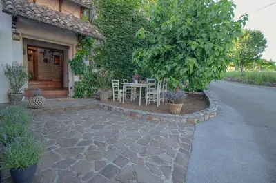 a patio with a table and chairs in front of a house at Apartment Ana - Karst Cycling Paradise in Dutovlje