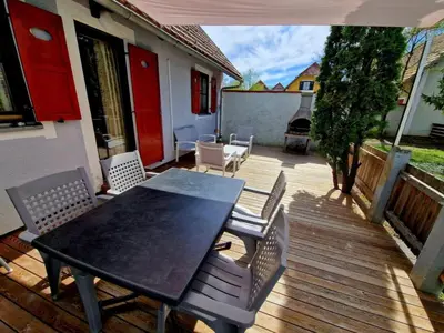 a patio with a table and chairs on a deck at Terme Čatež - Družinski apartma s kartami in Čatež ob Savi
