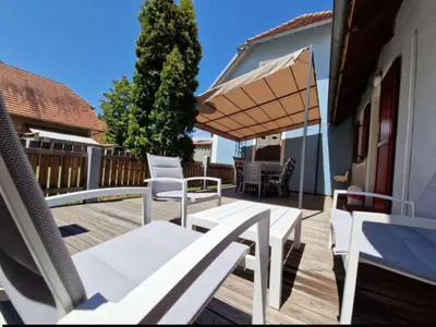 a patio with white chairs and an umbrella at Terme Čatež - Družinski apartma s kartami in Čatež ob Savi