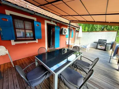 a table and chairs on a deck of a house at Terme Čatež - Družinski apartma s kartami in Čatež ob Savi