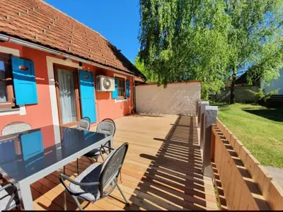 a wooden deck with chairs and a house at Terme Čatež - Družinski apartma s kartami in Čatež ob Savi