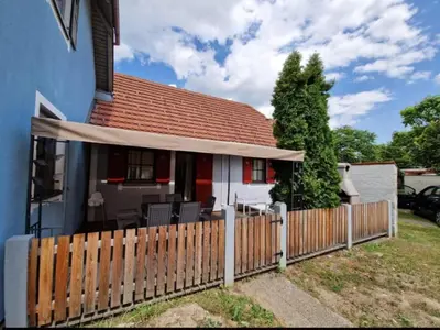a fence in front of a house with a patio at Terme Čatež - Družinski apartma s kartami in Čatež ob Savi