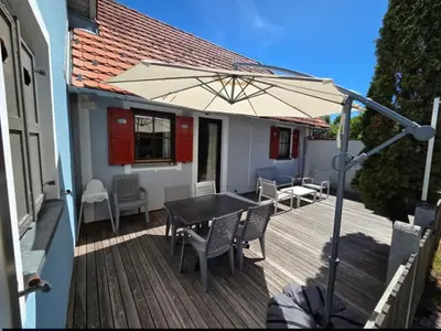 a wooden deck with a table and an umbrella at Terme Čatež - Družinski apartma s kartami in Čatež ob Savi