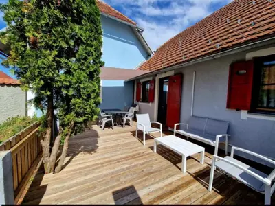 a wooden deck with benches and a tree at Terme Čatež - Družinski apartma s kartami in Čatež ob Savi