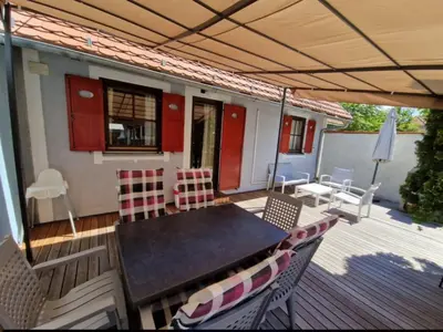 a patio with a table and chairs on a deck at Terme Čatež - Družinski apartma s kartami in Čatež ob Savi