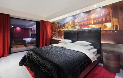 a bedroom with a black bed with a wall mural at Hotel Nox in Ljubljana
