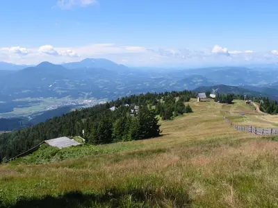 a grassy hill with houses on top of it at Apartmaji Snežinka Kope in Slovenj Gradec