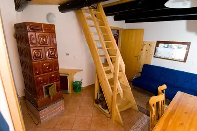 a living room with a wooden ladder and a blue couch at Apartmaji Snežinka Kope in Slovenj Gradec