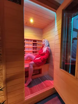 a woman is sitting in a sauna at Vineyard cottage Matej in Trebnje