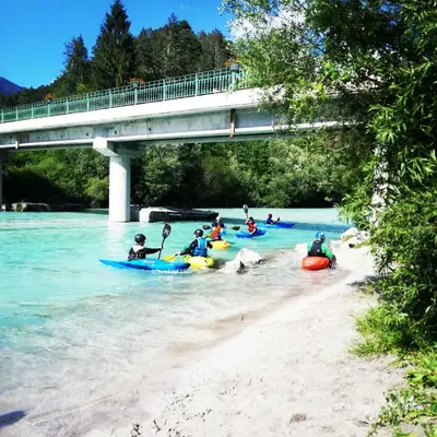 a group of people in kayaks in the water under a bridge at Alpine Relax Bovec in Bovec