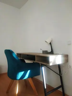 a desk with a blue chair in front of a desk at Apartmaji Sofia in Maribor