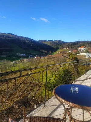 a table on a balcony with a view of a valley at Apartmaji Sofia in Maribor
