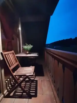 a chair sitting on a balcony with a view of the ocean at Holiday house apartment Voukov mlin in Šmarje pri Jelšah