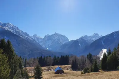 a tent in a field with mountains in the background at Apartma Kreda in Mojstrana