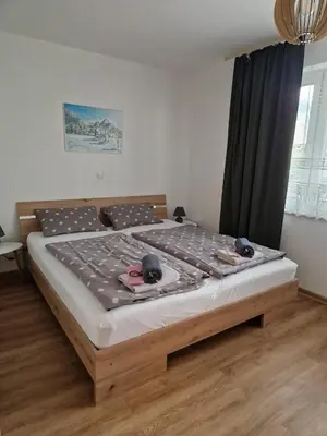 a bedroom with a large bed with shoes on it at Apartma Kreda in Mojstrana