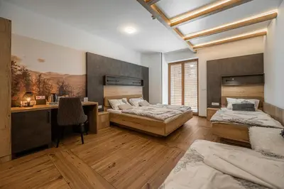 a bedroom with two beds and a desk and a desk at Veldes B&B in Bled