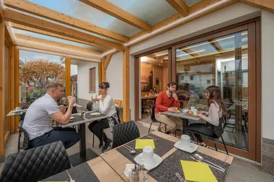a group of people sitting at tables in a restaurant at Veldes B&B in Bled