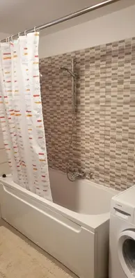 a bathroom with a tub and a washing machine at APARTMAJI VITEZ apartma 2 in Bovec