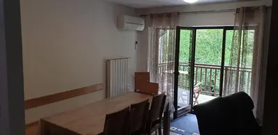 a dining room with a wooden table and a balcony at APARTMAJI VITEZ apartma 2 in Bovec