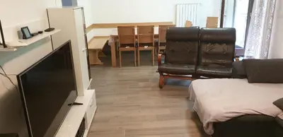a living room with a flat screen tv and two leather chairs at APARTMAJI VITEZ apartma 2 in Bovec