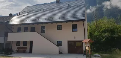 a large white house with a large roof at APARTMAJI VITEZ apartma 2 in Bovec