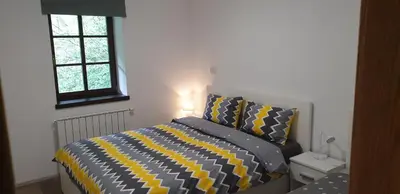 a bedroom with a bed with a yellow and black comforter at APARTMAJI VITEZ apartma 2 in Bovec