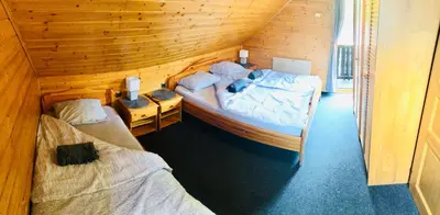 a bedroom with two beds in a wooden cabin at Holiday Cottage Krishtan in Podčetrtek