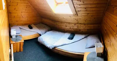 a room with two beds in a wooden cabin at Holiday Cottage Krishtan in Podčetrtek