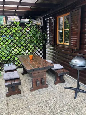 a picnic table and stool next to a cabin at Holiday Cottage Krishtan in Podčetrtek