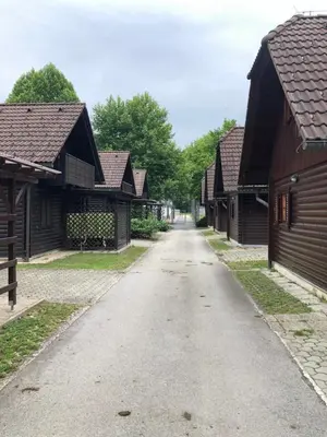 an empty road between two wooden buildings at Holiday Cottage Krishtan in Podčetrtek